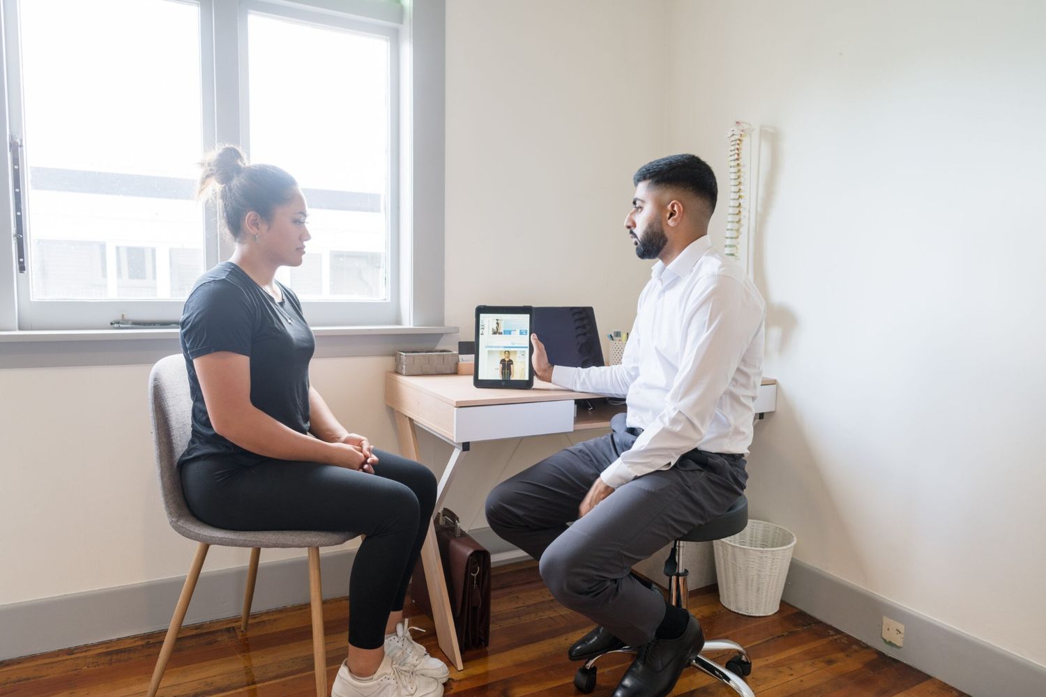 Patient speaking with chiropractor during a consultation in Mt. Eden