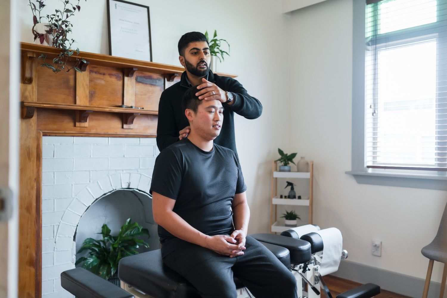 Chiropractor performing a neck adjustment at the Mt. Eden clinic